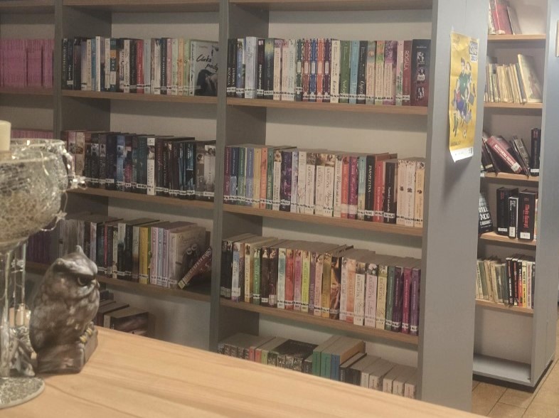 Zdjęcie przedstawiające regały z książkami i stolik dla czytelników.