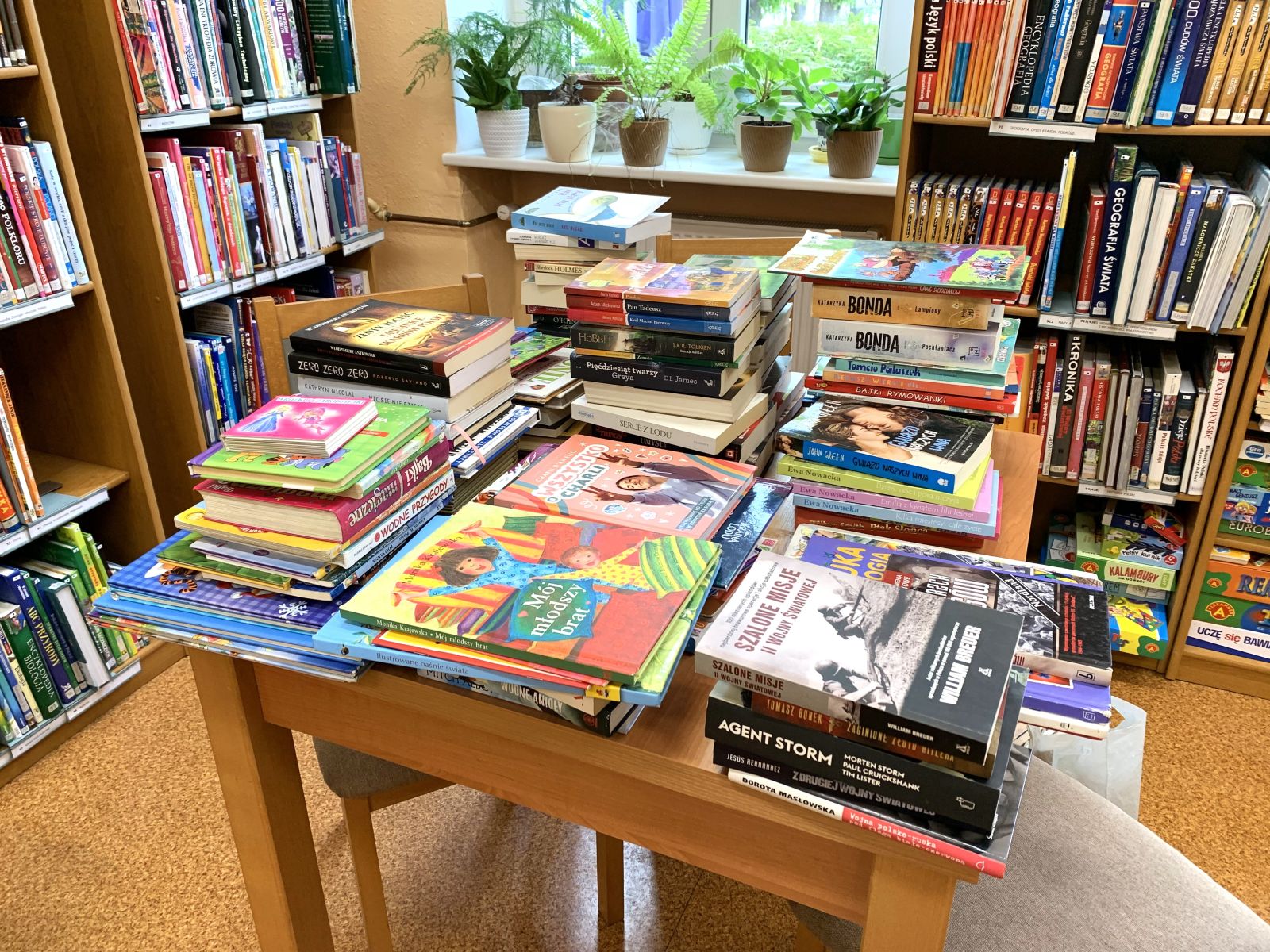 Stos książek na stole w bibliotece publicznej.